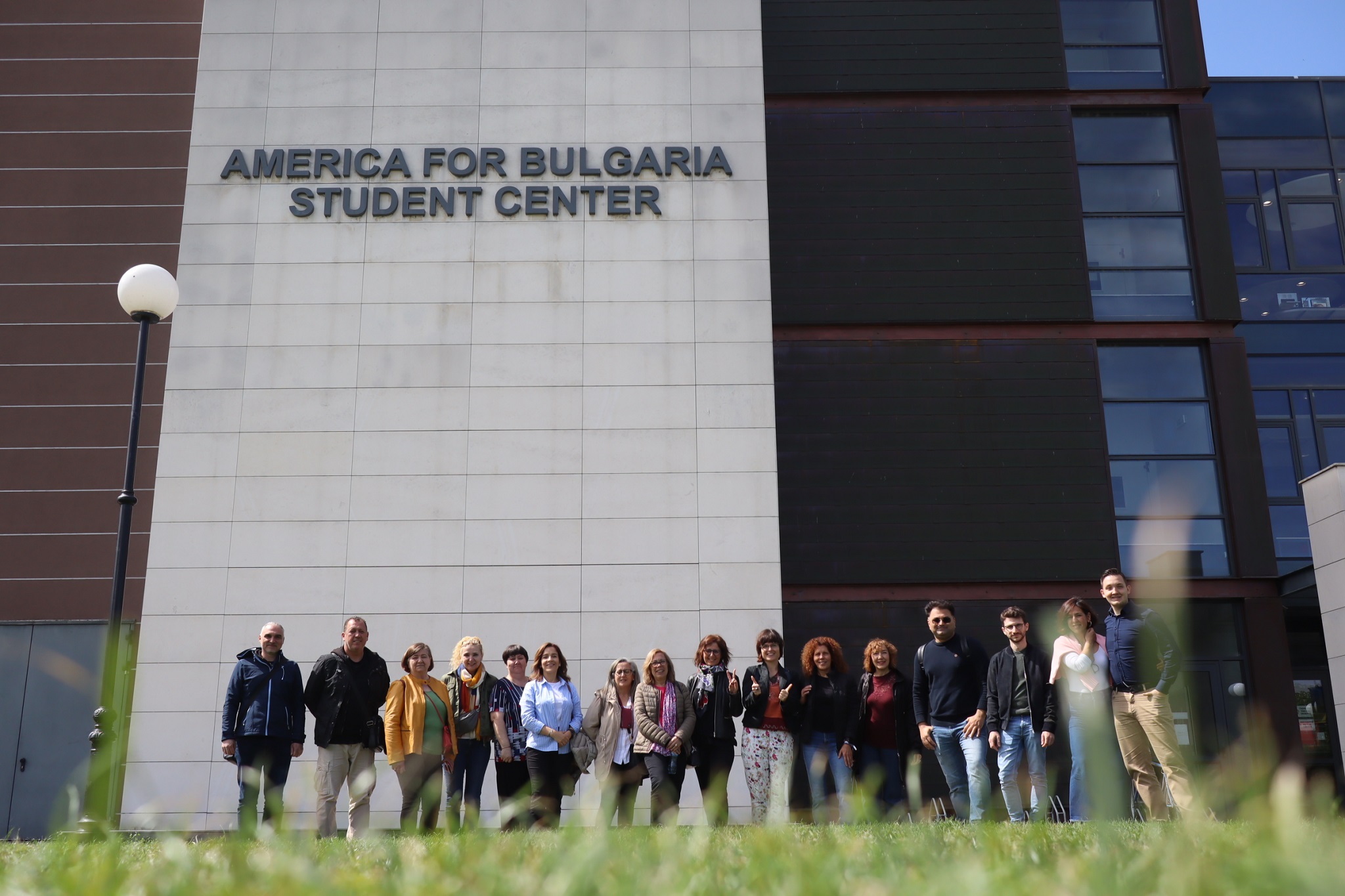 Zdjęcie grupy wykładowców na tle budynku Amerykańskiego Uniwersytetu w Bułgari