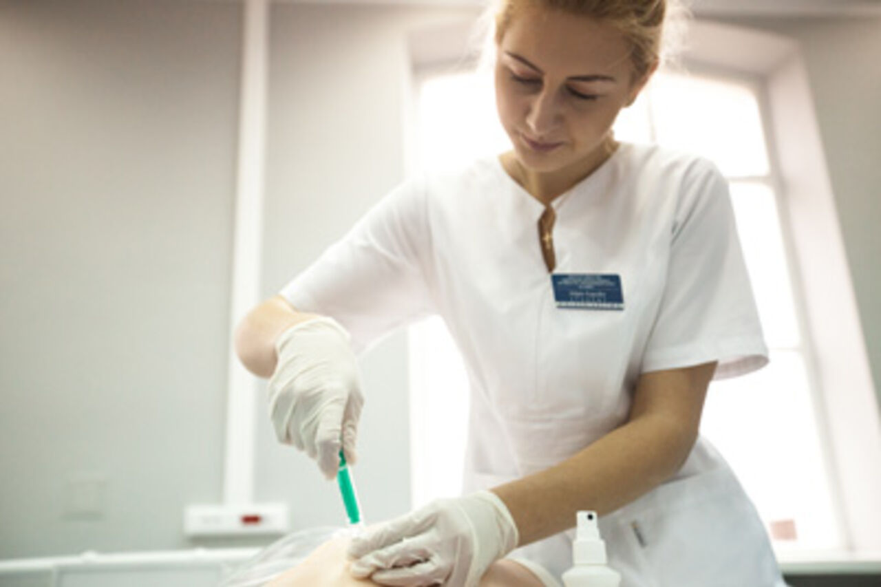 a nursing student performing an injection in the medical simulation centre