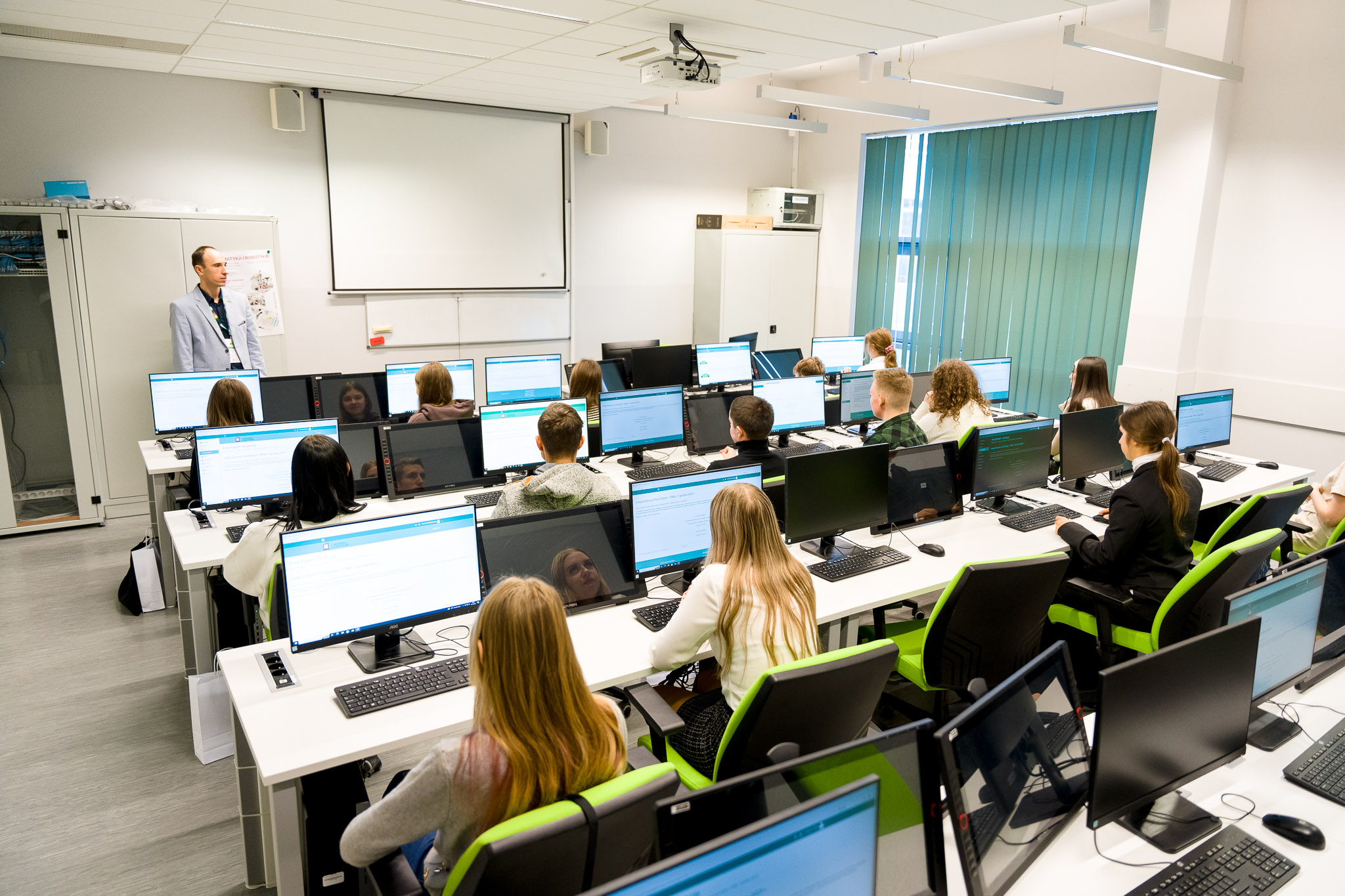 Wykładowca i uczniowie w sali komputerowej